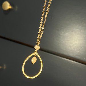 Long gold necklace with unique chain and pearly accents.